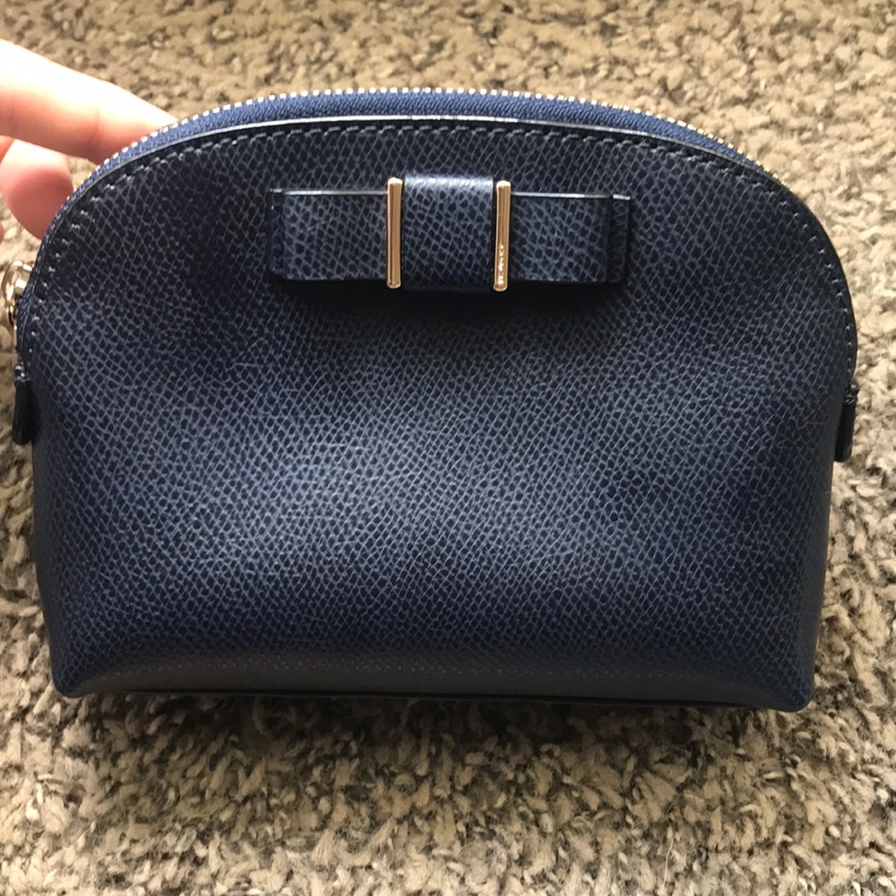Navy blue small coach zipper bag.